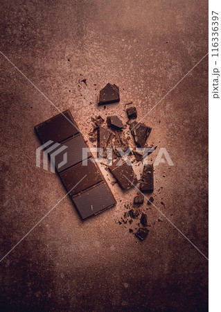 chocolate bar , for the manufacture of confectionery, broken, crumbled, on a brown background, top view, chocolate bar , for the manufacture of confectionery, broken, crumbled, on a brown background, top view, 116336397