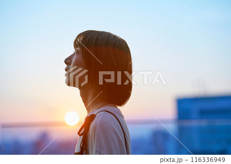 マジックアワーの街に立つ若い女性のポートレート 116336949