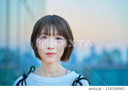マジックアワーの街に立つ若い女性のポートレート マジックアワーの街に立つ若い女性のポートレート 116336962