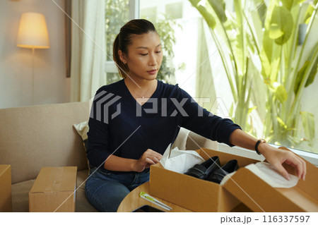 Woman Unpacking Parcel With Good 116337597