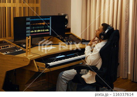 Composer Composing A Song At Mixing Console 116337614