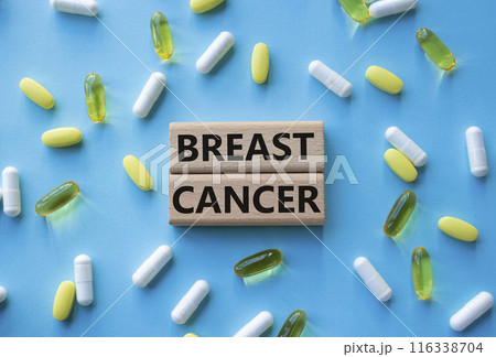Breast cancer symbol. Wooden blocks with words Breast cancer. Beautiful blue background with pills. Medicine and Breast cancer concept. Copy space. 116338704