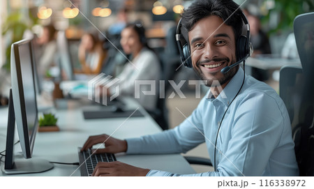 Photo of smiling man, a call center worker with a headset in the office 116338972