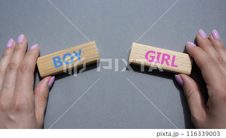 Boy or Girl symbol. Concept word Boy or Girl on wooden blocks. Man hand. Beautiful grey background. Gender and Boy or Girl concept. Copy space Boy or Girl symbol. Concept word Boy or Girl on wooden blocks. Man hand. Beautiful grey background. Gender and Boy or Girl concept. Copy space 116339003