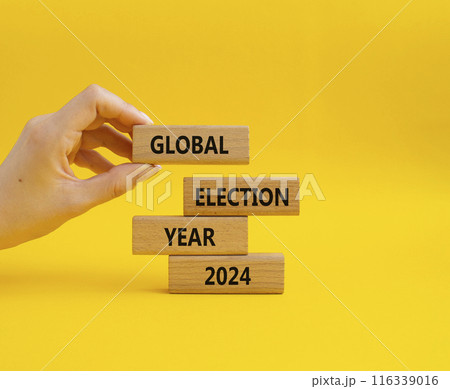 Global Election year 2024 symbol. Concept words Global Election year 2024 on wooden blocks. Beautiful yellow background. Businessman hand. Business and Global Election year 2024 concept. Copy space 116339016