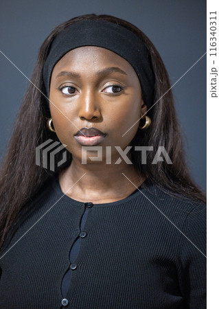 Portrait of a confident young woman in black exudes serious vibe, captured in modern style Portrait of a confident young woman in black exudes serious vibe, captured in modern style 116340311