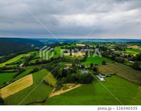 Aerial view captures lush countryside with rolling hills and farmland stretching into the distance 116340335