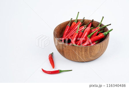 Red hot chili pepper in a wooden bowl on a white background close-up. Copy space Red hot chili pepper in a wooden bowl on a white background close-up. Copy space 116340486