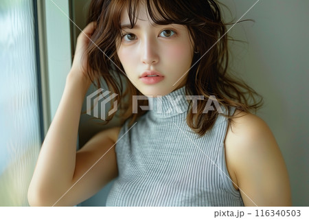 グレーのノースリーブサマーニットを着る女性 116340503