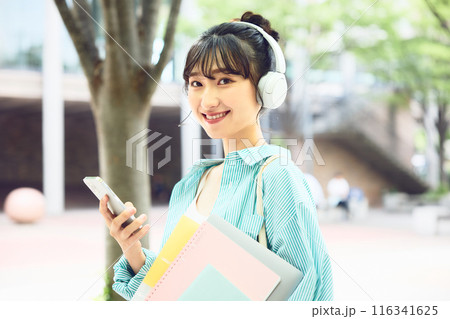 ヘッドフォンで音楽を聴く女子大学生 116341625