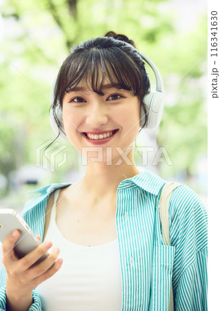 ヘッドフォンで音楽を聴く女子大学生 116341630