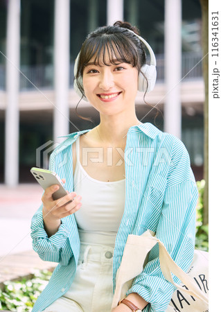 ヘッドフォンで音楽を聴く女子大学生 ヘッドフォンで音楽を聴く女子大学生 116341631