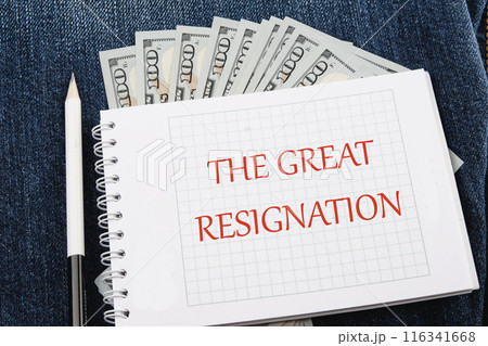 The words THE GREAT RESIGNATION on a checkered notebook in a composition with dollars bills and a pencil 116341668