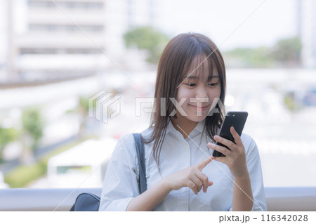 街中でカバンを持った女子高生 116342028