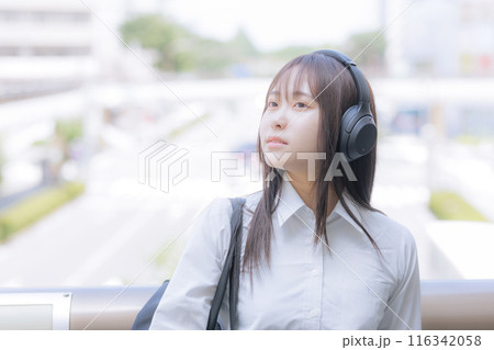 街中で音楽を聴く女子高生 116342058
