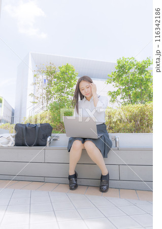 街中で座ってパソコン使う女子高生 街中で座ってパソコン使う女子高生 116342186