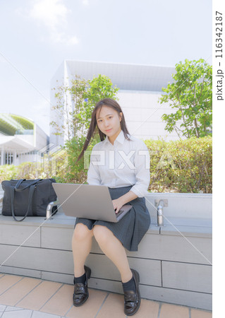 街中で座ってパソコン使う女子高生 街中で座ってパソコン使う女子高生 116342187