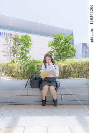 街中で座って勉強をしている女子高生 街中で座って勉強をしている女子高生 116342266