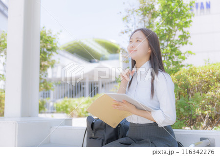 街中で座って勉強をしている女子高生 116342276