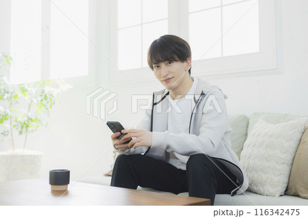 リビングでくつろぐ若い男性 リビングでくつろぐ若い男性 116342475