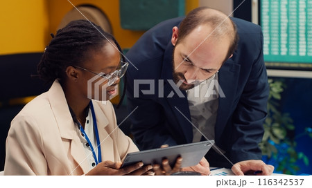 Management team developing new digital transformation initiatives in a boardroom meeting, enhance operational efficiency and agility. Employees improve organization workflow and performance. Camera A. 116342537