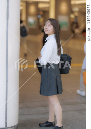 街中でカバンを持って待ち合わせをする女子高生 116343978
