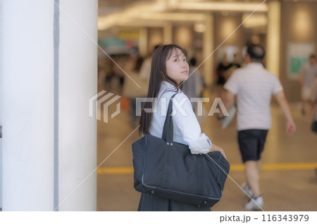 街中でカバンを持って待ち合わせをする女子高生 116343979