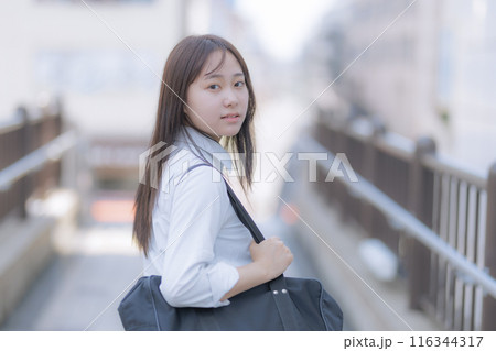 街中でカバンを持って歩く女子高生 116344317