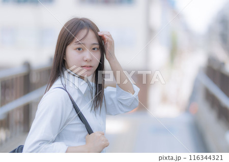 街中でカバンを持って歩く女子高生 116344321