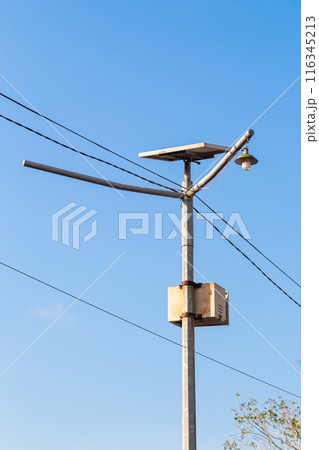 metal pole with common lights and cables with sky background 116345213