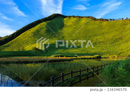 2024年夏曽爾高原の夕景　夕日を受けて美しい山肌を見せる倶留尊山と豊かな水を湛えたお亀池　横構図④ 116346570