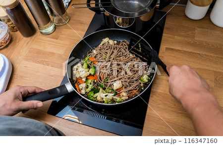 Chef at the kitchen preparing japanese buckwheat pasta with lentils 116347160