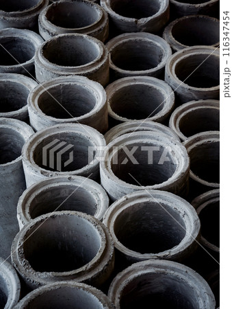 A stack of concrete ring pipes piled and creating a symmetrical arrangement 116347454