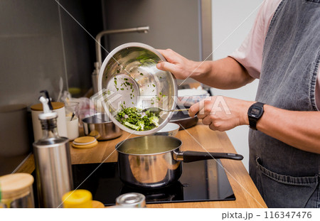 Chef at the kitchen preparing green curry with herbs and rice 116347476