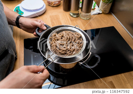 Chef at the kitchen preparing japanese buckwheat pasta with lentils 116347592