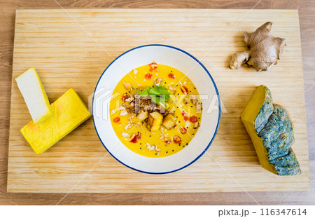 A bowl of pumpkin porridge with tofu and vegetables 116347614