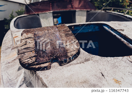 Old and rusty motor boats on a landfill surrounded by tropical forest Old and rusty motor boats on a landfill surrounded by tropical forest 116347743