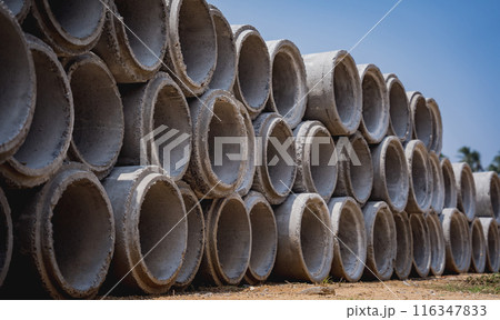A stack of concrete ring pipes piled and creating a symmetrical arrangement 116347833