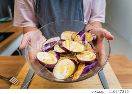 Chef at the kitchen preparing grilled eggplants with garlic Chef at the kitchen preparing grilled eggplants with garlic 116347856