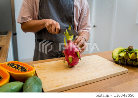 Chef cuts and peels dragon fruit on the cutting board Chef cuts and peels dragon fruit on the cutting board 116348050