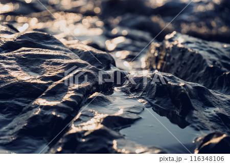 A large rocks surrounded by waves of the ocean A large rocks surrounded by waves of the ocean 116348106