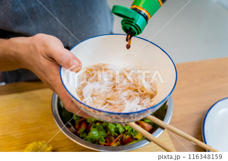Chef at the kitchen preparing spicy glass noodle salad Chef at the kitchen preparing spicy glass noodle salad 116348159