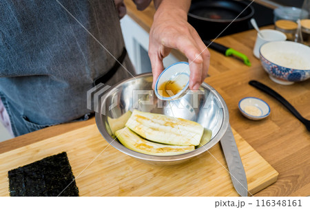 Chef at the kitchen preparing grilled eggplants with garlic Chef at the kitchen preparing grilled eggplants with garlic 116348161