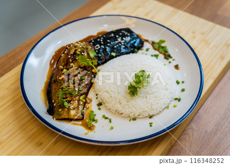 Delicious grilled eggplants with garlic on the white plate Delicious grilled eggplants with garlic on the white plate 116348252