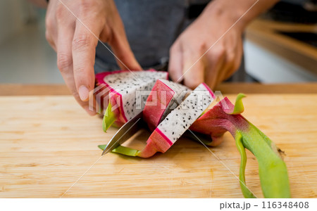 Chef cuts and peels dragon fruit on the cutting board 116348408