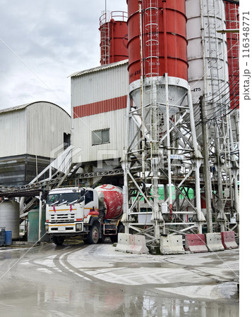 A concrete mixer truck is stationary outside of a concrete factory 116348771