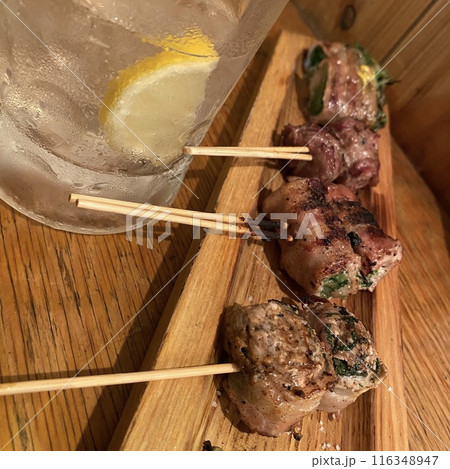 【焼き鳥・焼きとん】居酒屋のカウンターで野菜肉巻きの串焼き盛り合わせとレモンサワー 116348947