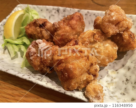 【居酒屋･揚げ物】ジューシーな鶏の唐揚げとレモン(斜めから･アップ) 116348950
