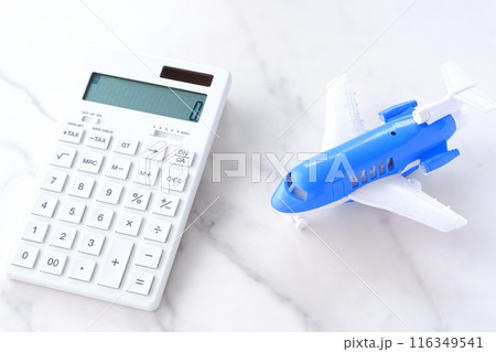 電卓と飛行機で、高騰する航空券代と、高騰する旅行代金のイメージ 116349541