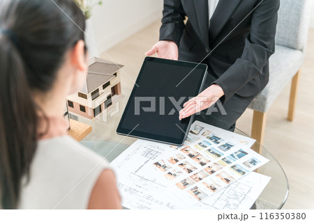 タブレット・設計図・図面を見ながらマイホームのリフォームを提案をするビジネスウーマンの手元 116350380